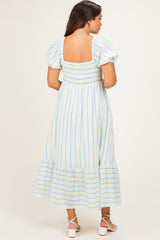 woman wearing a striped maternity maxi dress with puff sleeves and a smocked back, featuring a tiered hem