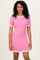 woman wearing a pink ribbed dress with white ruffle trim on the sleeves and neckline