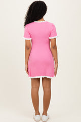 woman wearing a pink ribbed short sleeve dress with white trim and a fitted silhouette