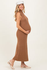 woman wearing a brown sleeveless ribbed knit maternity dress and holding her baby bump