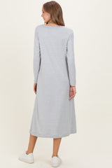 woman wearing a light gray long sleeve maternity dress, shown from the back, with a relaxed fit and ankle length