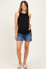 woman wearing a black maternity tank top and denim shorts, holding her baby bump