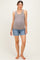 woman wearing a gray ribbed maternity tank top and denim shorts, showing her baby bump