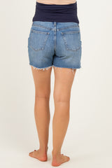 woman wearing maternity denim shorts with a frayed hem, showing the back view and no visible baby bump