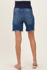 woman wearing dark wash maternity denim shorts with a stretchy waistband and frayed hem.