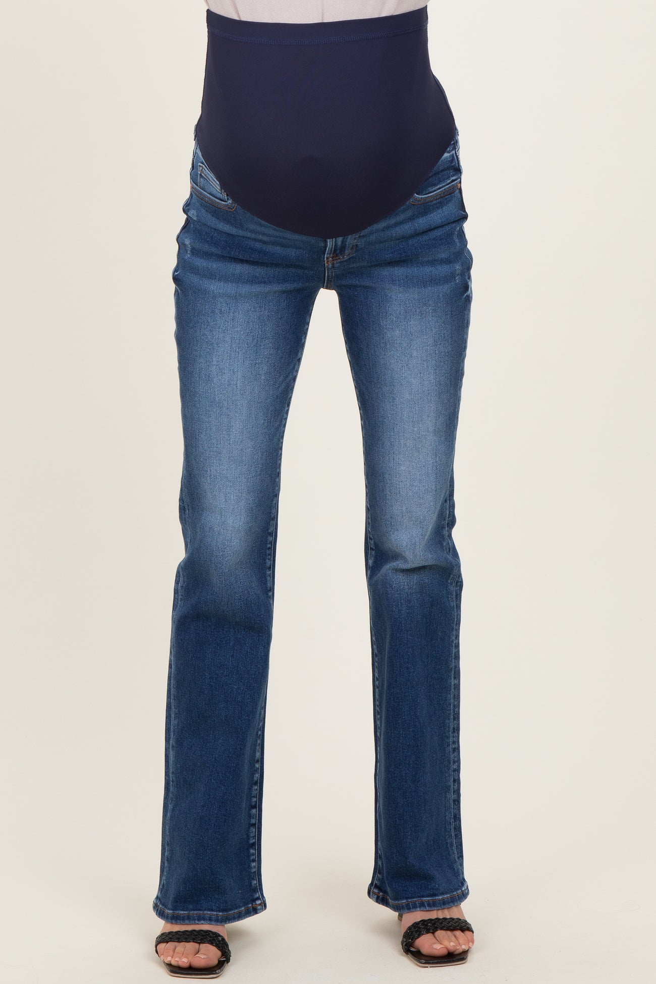 woman wearing dark blue maternity jeans with a stretchy over-the-bump waistband and a flared leg style