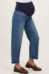 woman wearing a pair of blue maternity jeans with a black belly support panel and styled with brown loafers