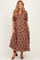 woman wearing a brown floral print maternity dress with a v-neck and puff sleeves, showing her baby bump