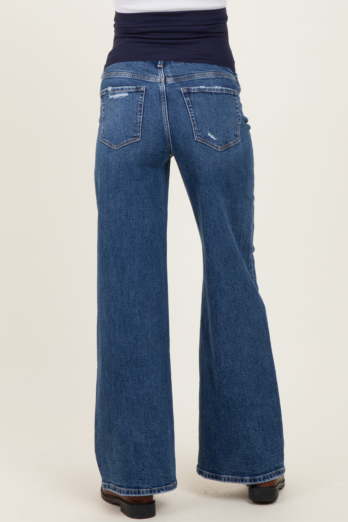woman wearing distressed wide leg maternity jeans with a stretchy waistband from the back