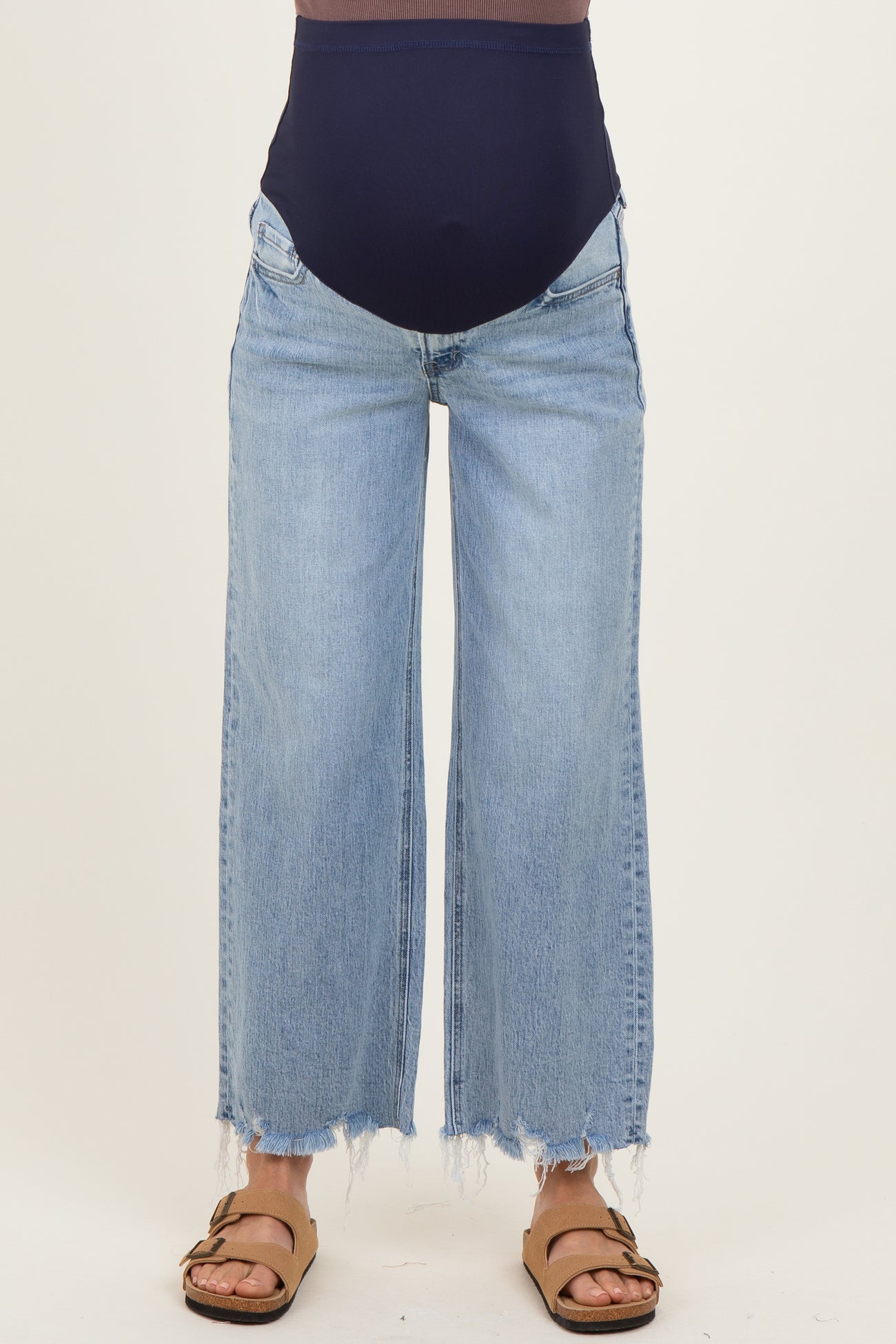 woman wearing light blue maternity wide-leg jeans with a high waistband and frayed hems