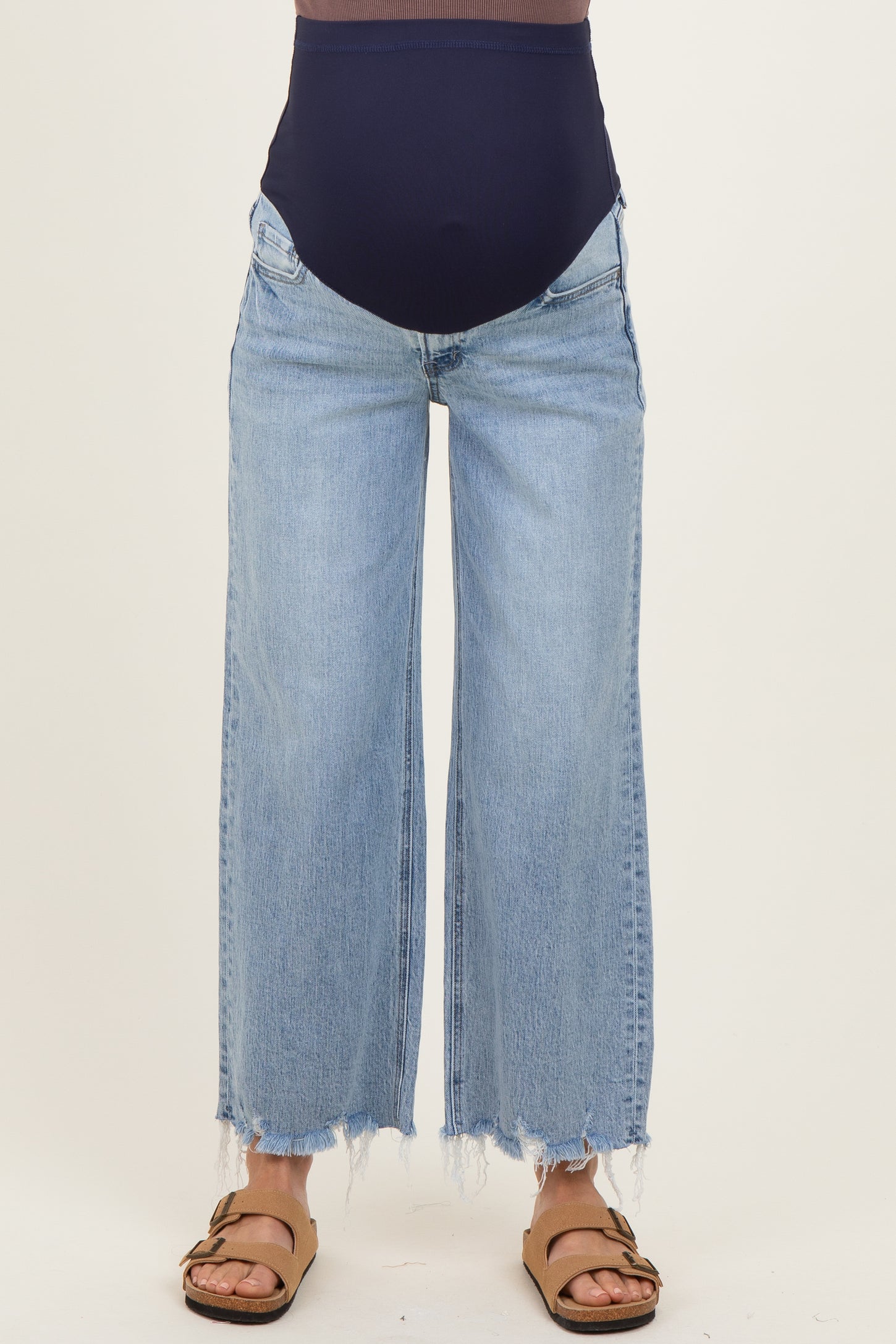 woman wearing light blue maternity wide-leg jeans with a high waistband and frayed hems