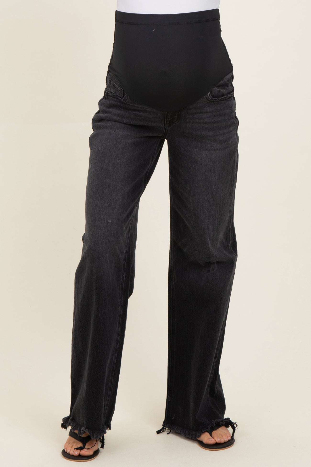 maternity black wide leg jeans with a high waistband and distressed details, model wearing sandals