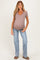woman wearing a taupe v-neck maternity top with gathered sides and light blue flared jeans, showing her baby bump