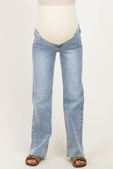 woman wearing light blue maternity flare jeans with a support panel for a baby bump