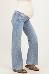 woman wearing light blue maternity jeans with a stretchy belly panel and frayed hem, showing her baby bump