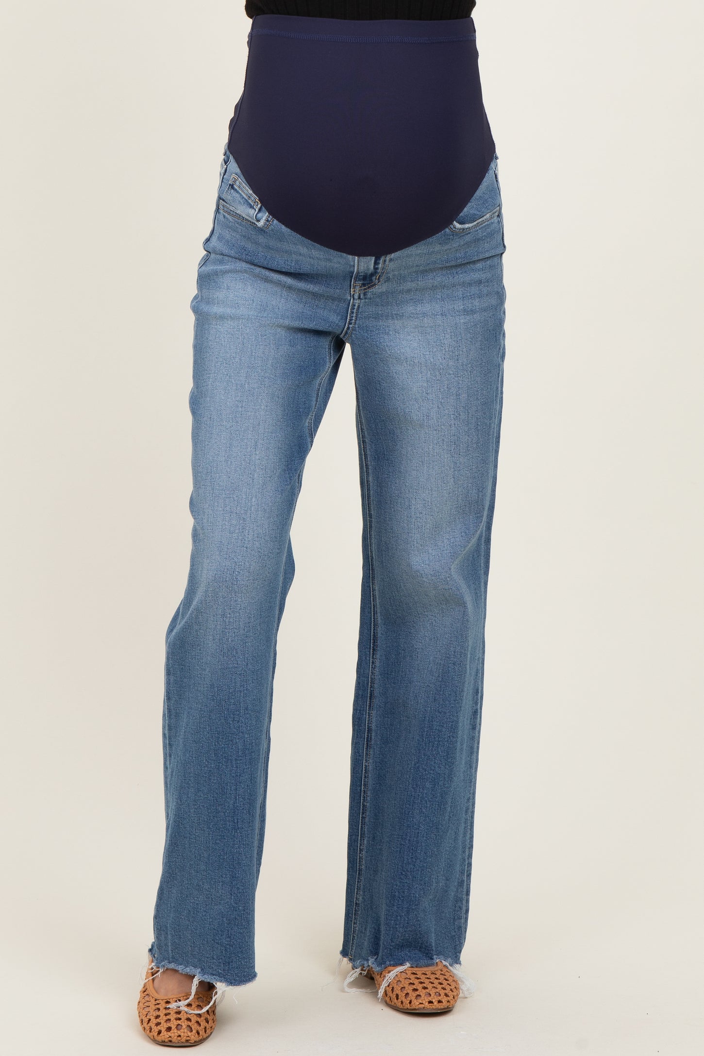 woman wearing navy blue maternity jeans with a high waistband and a flared leg style
