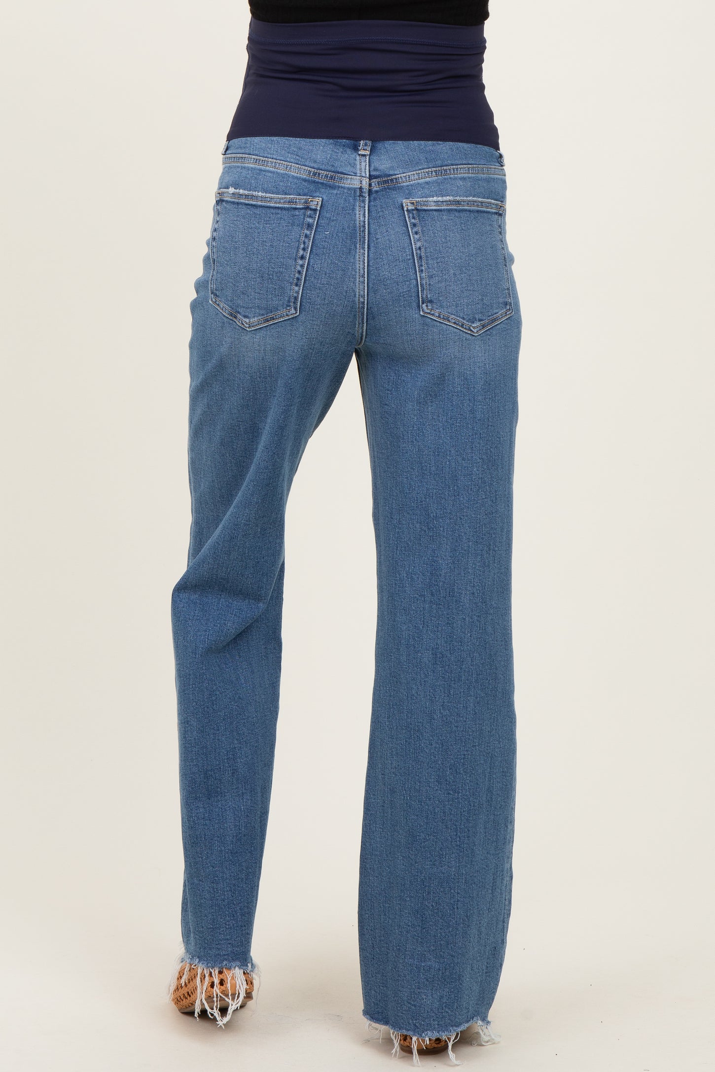 woman wearing a pair of light wash maternity jeans with a stretchy waistband, shown from the back