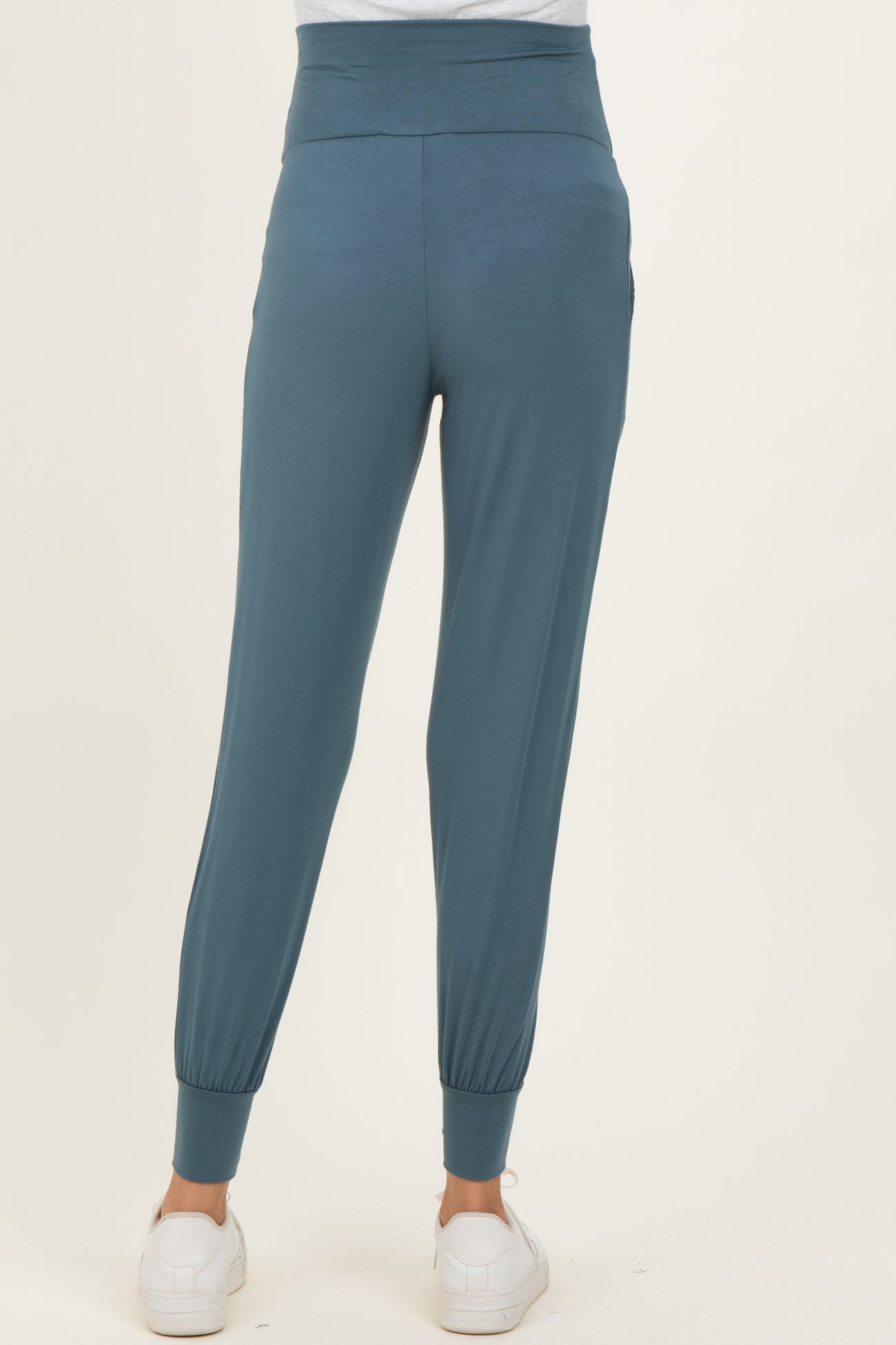 woman wearing teal maternity joggers with a tapered leg and elastic cuffs, showing the back view