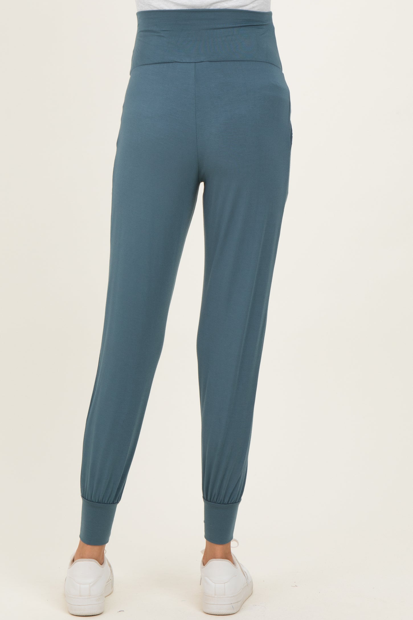 woman wearing teal maternity joggers with a tapered leg and elastic cuffs, showing the back view