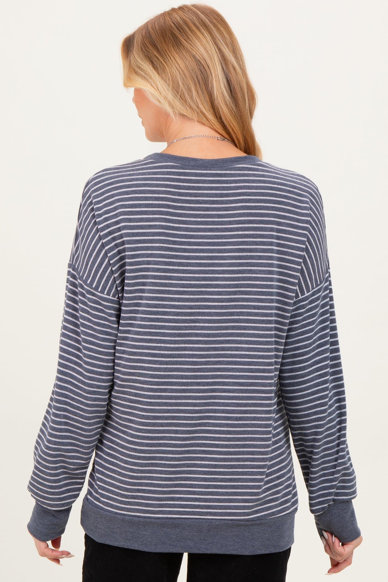 woman wearing a gray and white striped maternity sweatshirt with a relaxed fit and long sleeves