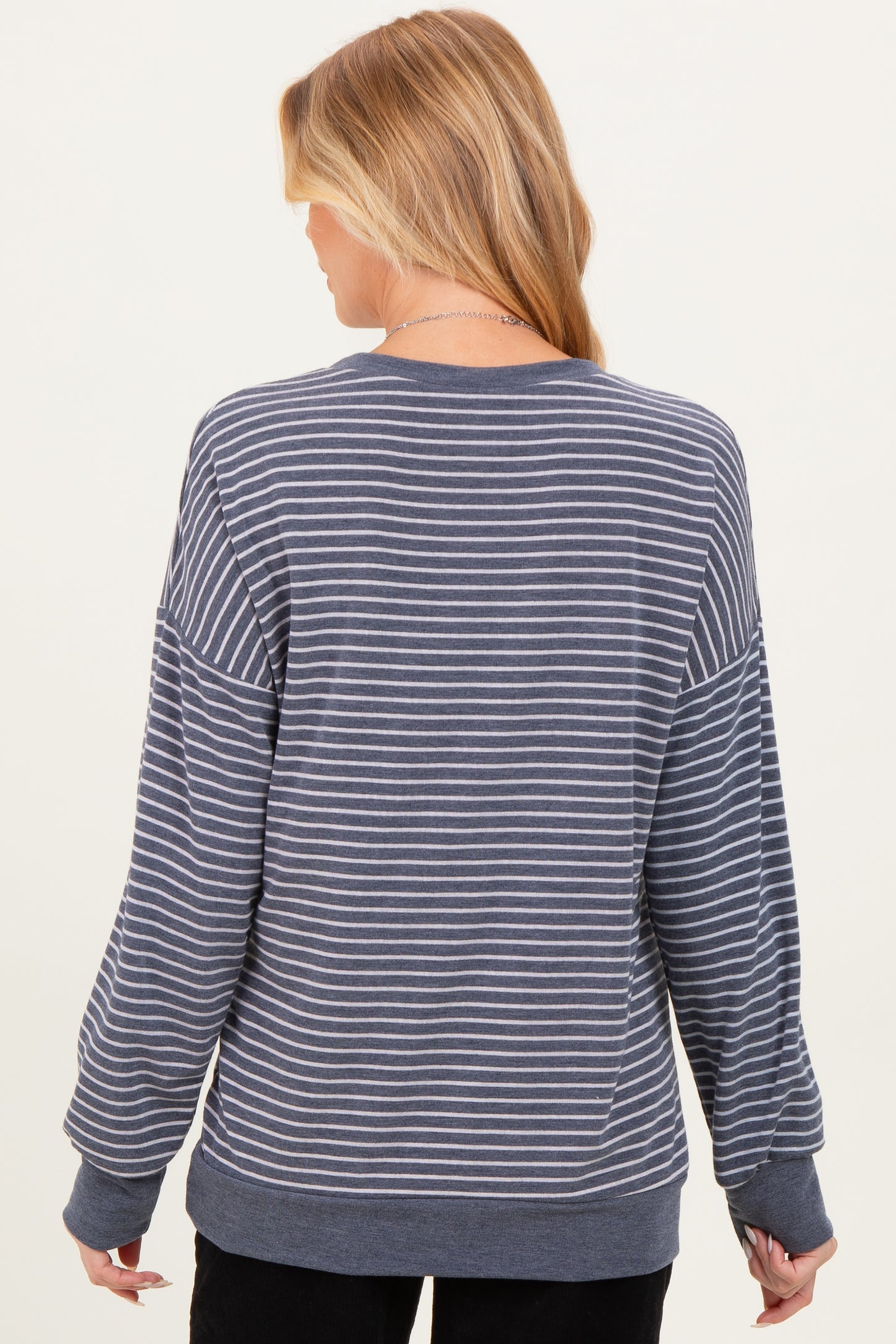 woman wearing a gray and white striped maternity sweatshirt with a relaxed fit and long sleeves
