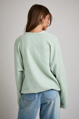 woman wearing a soft mint green oversized sweater with a relaxed fit and back view, paired with light blue jeans