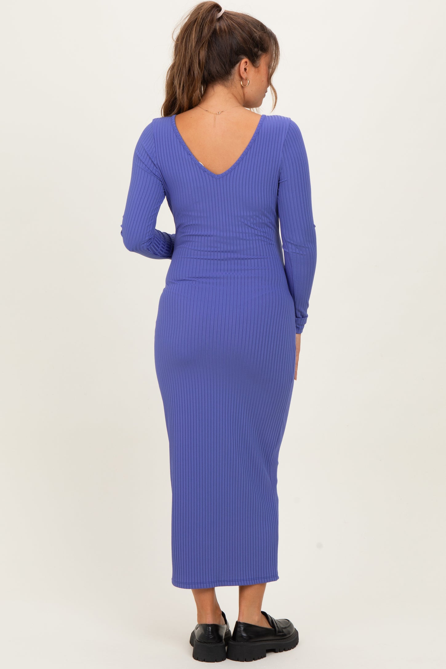 woman wearing a purple ribbed maternity dress with a v-back and long sleeves
