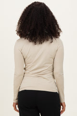 woman wearing a beige long sleeve top viewed from the back with curly hair