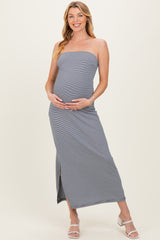 woman wearing a striped navy blue strapless maternity maxi dress and holding her baby bump