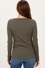 woman wearing an olive green ribbed long sleeve top, seen from the back, paired with blue jeans