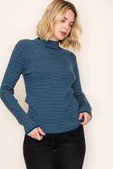 woman wearing a navy and white striped long sleeve turtleneck top with relaxed fit and side slits