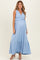 woman wearing a light blue maternity maxi dress with ruffle details and a visible baby bump