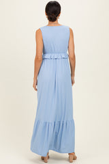 woman wearing a light blue sleeveless maxi dress with a ruffled waist and tiered skirt, viewed from the back