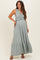 woman wearing a light green striped maternity maxi dress with a ruffled neckline and flared hem, showcasing her baby bump