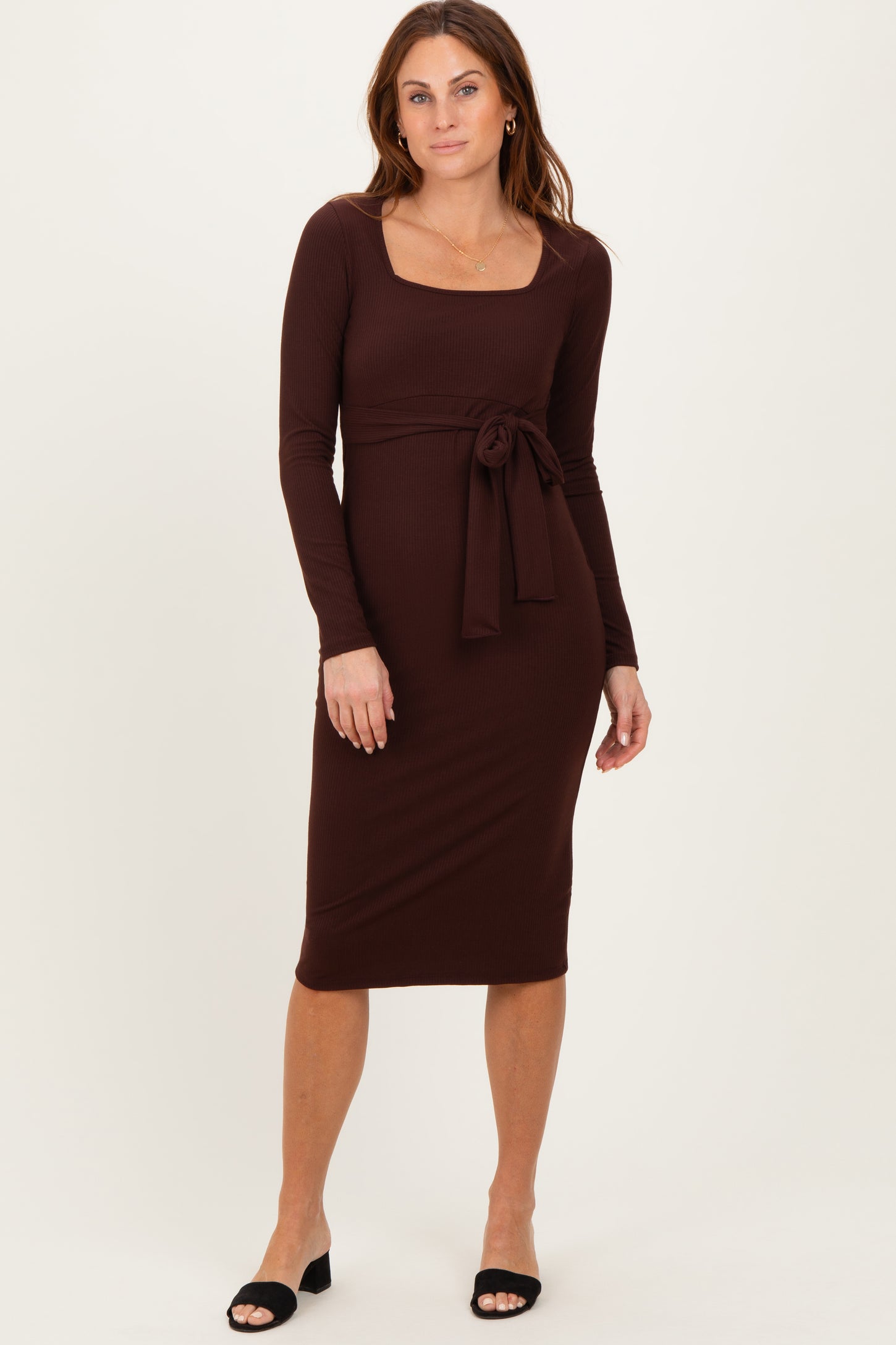woman wearing a brown long sleeve dress with a square neckline and tie waist detail