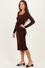 woman wearing a brown long sleeve midi dress with a tie waist detail and a fitted silhouette