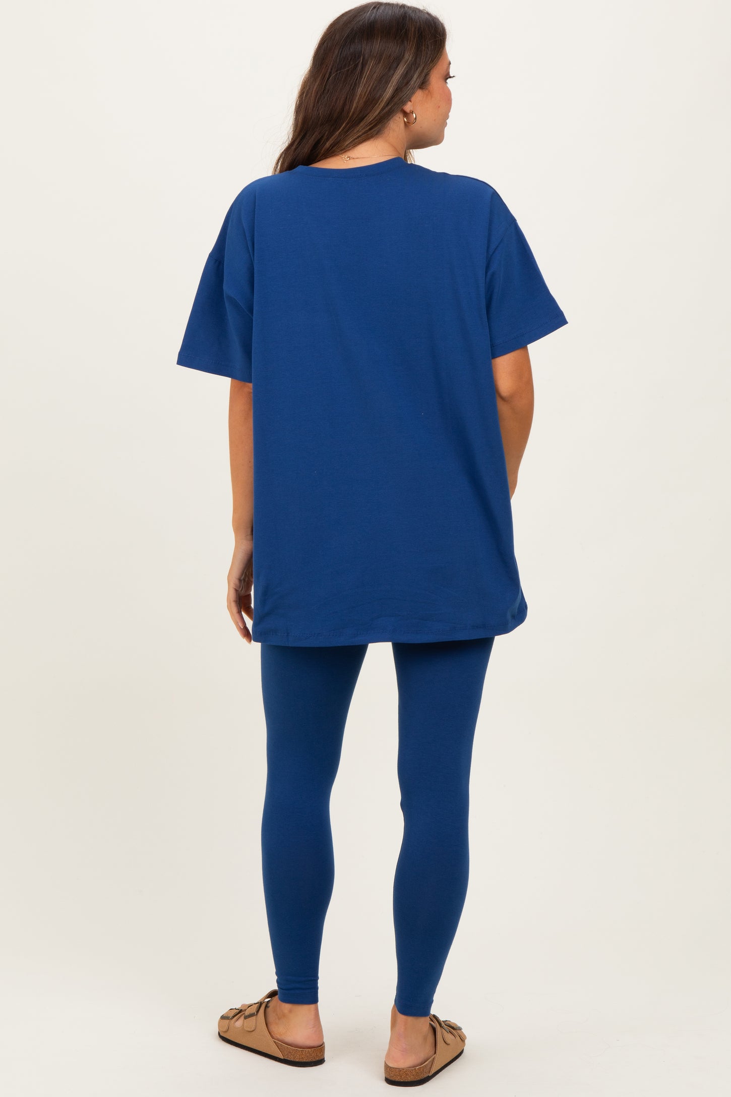 woman wearing a blue oversized maternity t-shirt and matching leggings, showcasing a relaxed fit and comfort