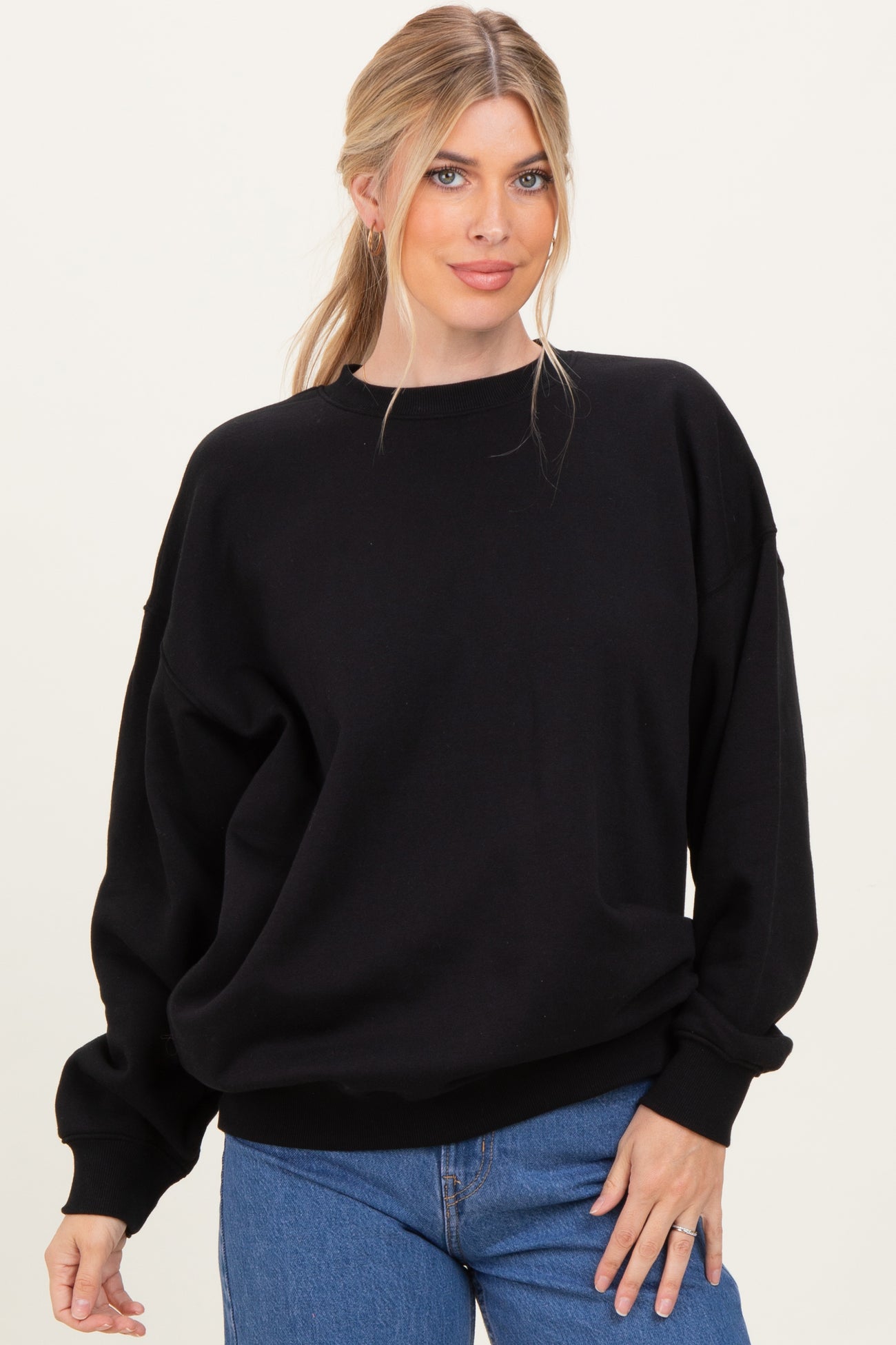 woman wearing a black oversized sweatshirt and blue jeans with a relaxed fit