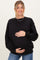 woman wearing a black oversized maternity sweatshirt and holding her baby bump