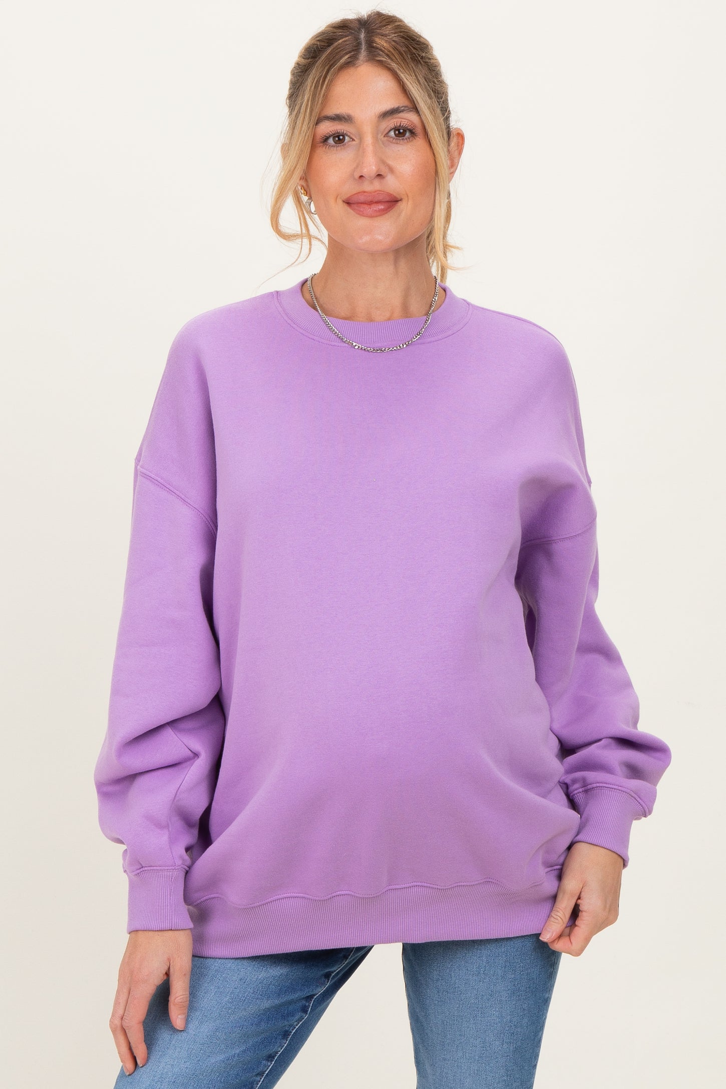 woman wearing a lavender oversized maternity sweatshirt with long sleeves and a relaxed fit, showcasing a baby bump
