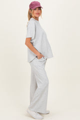 woman wearing a gray maternity loungewear set with a loose top and wide-leg pants, showcasing her baby bump