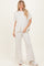 woman wearing a light grey relaxed fit top and matching wide leg pants with sneakers