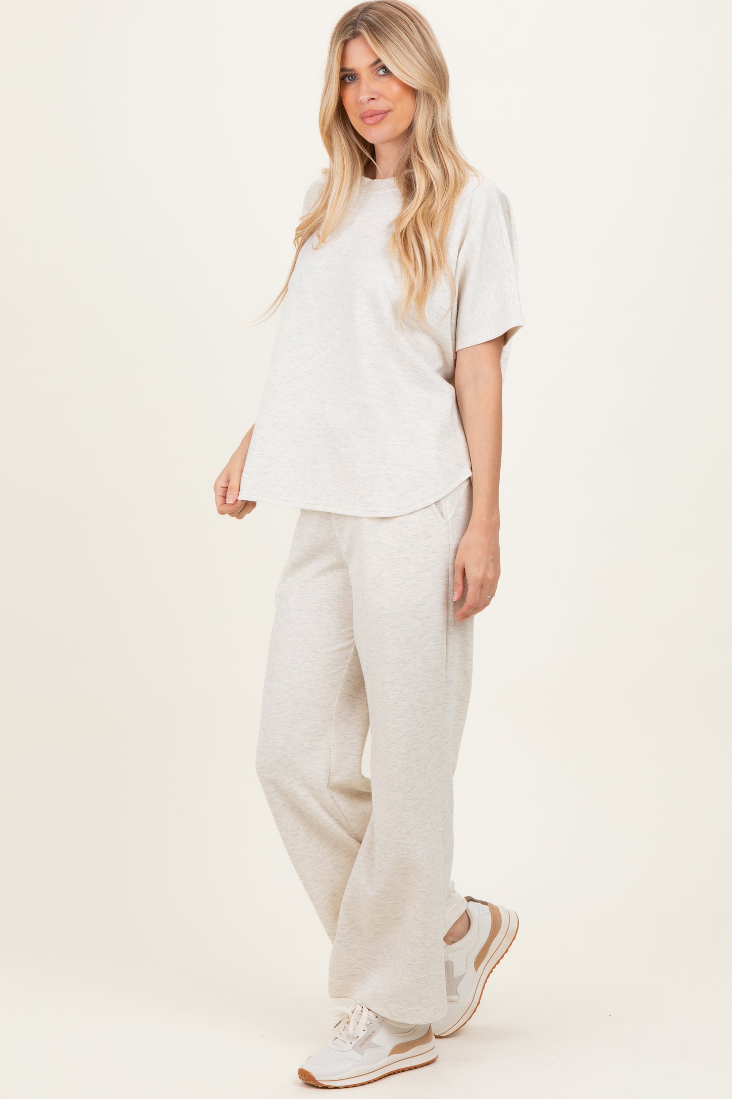 woman wearing a light grey oversized t-shirt and matching sweatpants, paired with white sneakers