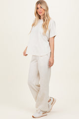 woman wearing a light grey oversized t-shirt and matching sweatpants, paired with white sneakers