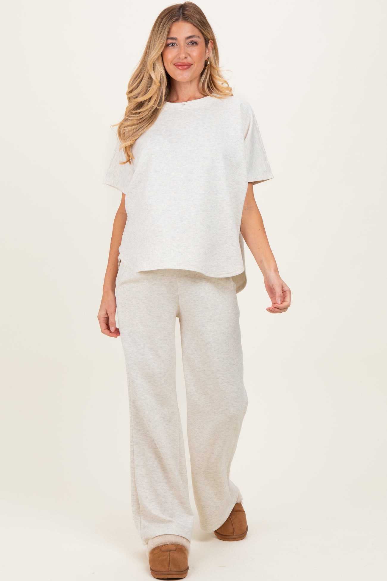 woman wearing a light gray maternity lounge set with a relaxed top and wide-leg pants