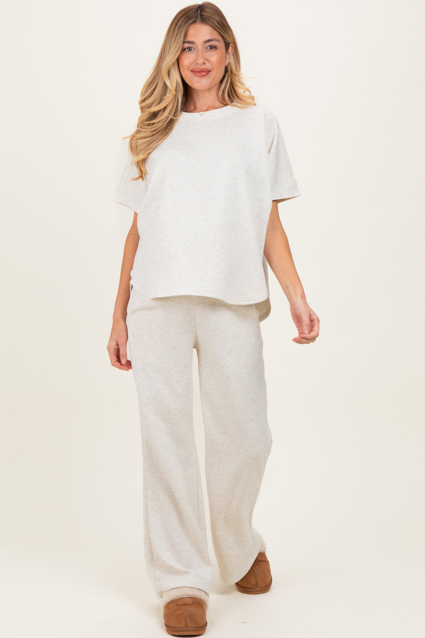 woman wearing a light gray maternity lounge set with a relaxed top and wide-leg pants