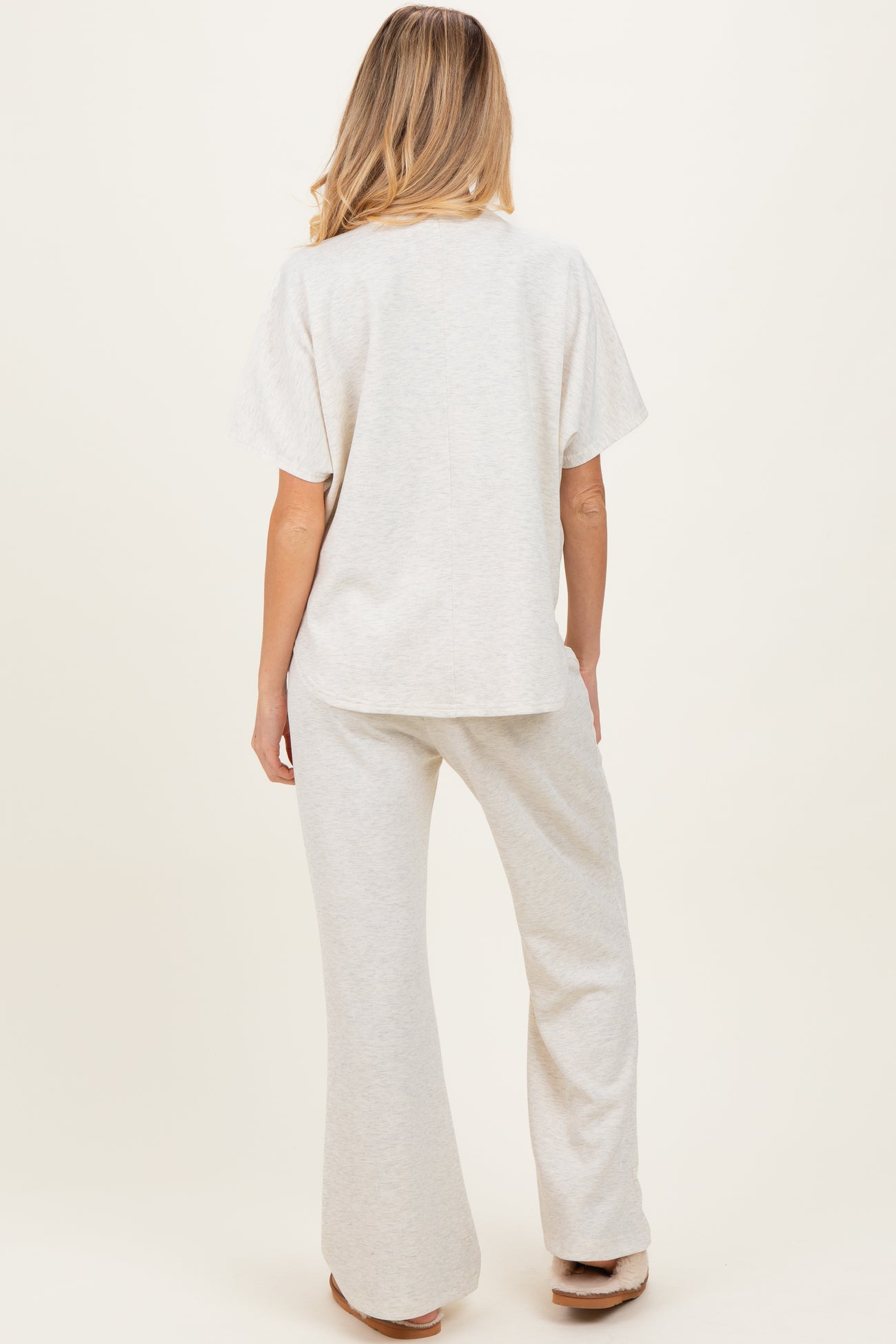 woman wearing a light gray maternity lounge set with a relaxed fit top and wide leg pants, showing the back view
