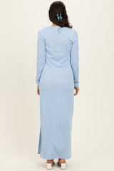 woman wearing a light blue ribbed maxi dress with long sleeves and side slits, viewed from the back