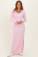woman wearing a light pink long sleeve ribbed maxi dress with side slits and white sneakers