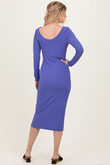 woman wearing a purple ribbed long sleeve midi dress, showing the back view with scoop neck design